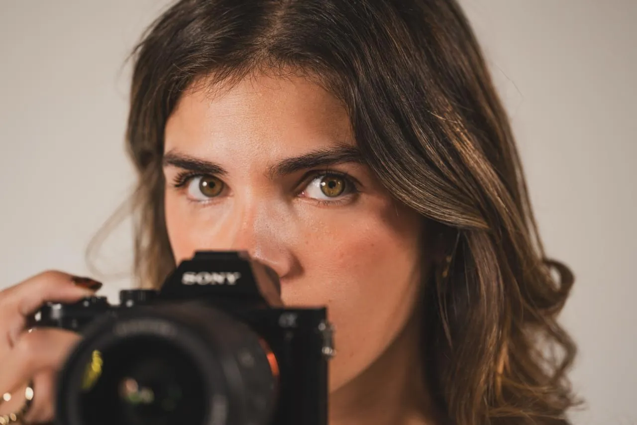 Angèle Octobon regarde l'objectif par-dessus son appareil photo