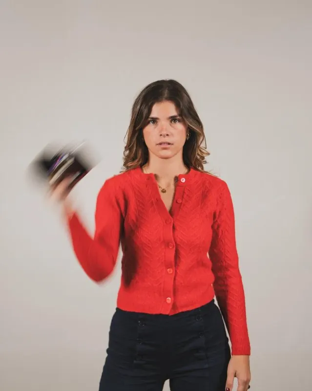 Angèle en gilet rouge, son appareil photo en mouvement